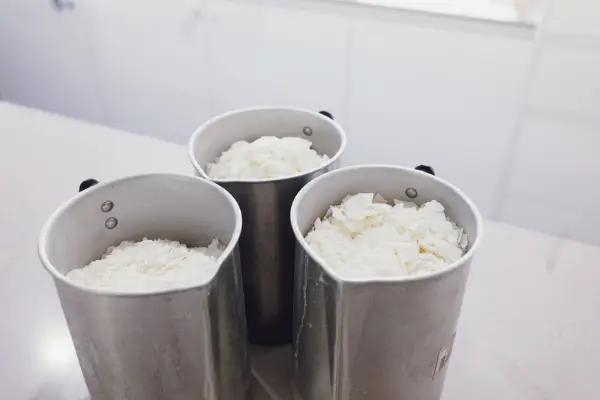 Three containers which have soy wax flakes in them