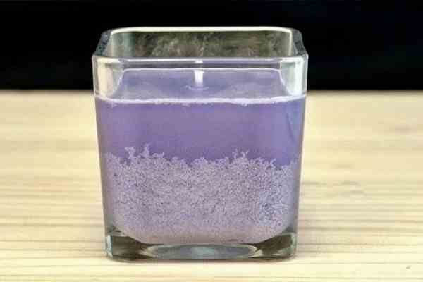 A photo of a purple candle with white frosting