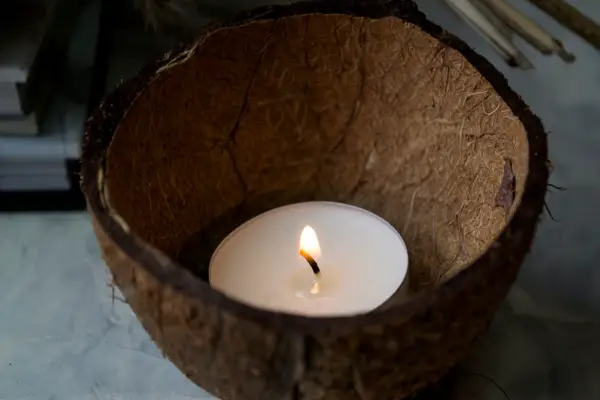 A photo of a coconut tealight candle in half a coconut shell