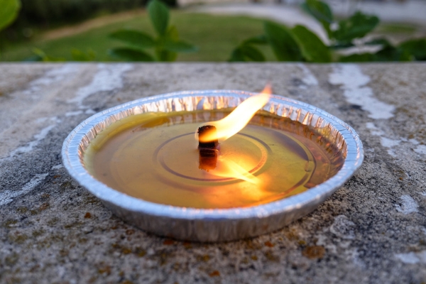A photo of a melted citronella candle in a foil tray