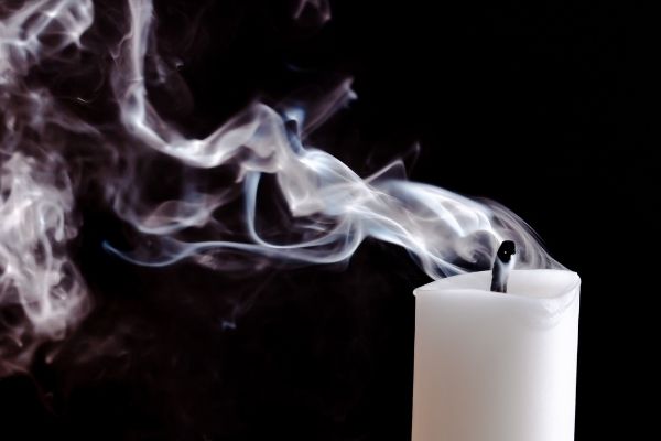 A photo of a candle showing the release of fumes