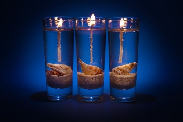 3 clear gel wax candles with sea shells embedded into the gel wax
