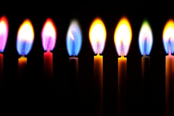 A photo of spiritual candles each with different colored flames