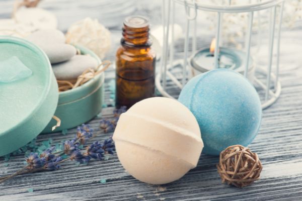 A photo of a bath bomb and a bottle of essential oil