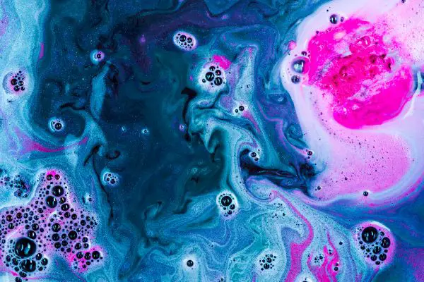 A Lush Intergalactic bath bomb dissolving in the bath revealing strong coloring