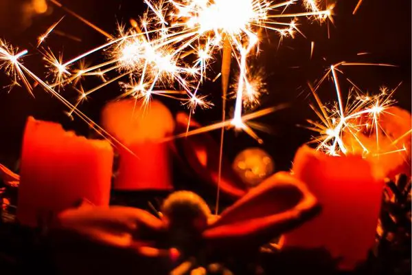 A photo of four candles that are crackling and spitting